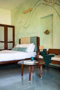 a bedroom with two beds and a coffee table at illa - By the sea in Udupi