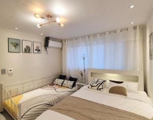 a bedroom with two beds and a window at Maison Stay in Samgong