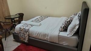 a bed with pillows on it in a room at Kukis Place, 5 bedrooms, whole compound in Embu