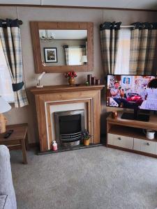 a living room with a fireplace and a television at St Minver Hideaway in Saint Minver