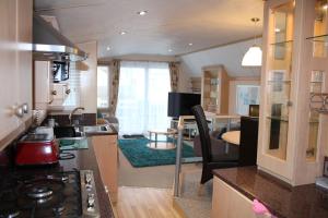 a kitchen and living room with a stove top oven at Golden sands ingoldmells plot 337 in Skegness