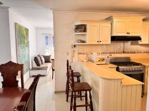 a kitchen with white cabinets and a table and chairs at 1Dom Rep - Huge cozy 3 bedrooms - close to all transportation Jacobo Majluta - Residencial Paradise V Colina Arroyo 1 in Santo Domingo