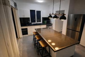 a kitchen with a counter top and a refrigerator at Villa 4 étoiles Le Pic de Malendure in Bouillante