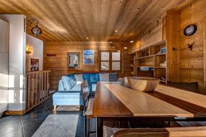 a living room with a wooden ceiling and a table at Tiny Chalet - near to Servoz train station in Les Houches