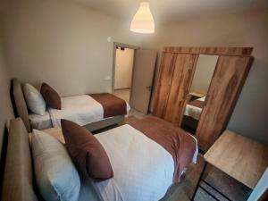a hotel room with two beds and a mirror at Suitev in Arnavutköy