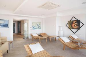 a room with wooden chairs and a painting on the wall at Hotel Raito in Vietri sul Mare