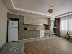 an empty kitchen with a refrigerator and a table at Suitev in Arnavutköy