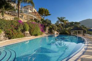 a large blue swimming pool with a house in the background at Hotel Raito in Vietri sul Mare