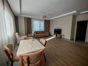 a living room with a table and chairs and a couch at Suitev in Arnavutköy +8 photos