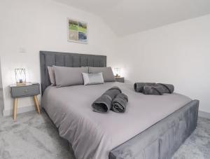 a bedroom with a large bed and a night stand at The View - Peaceful Duplex Apartment with Views, Parking & Wifi in Nuneaton