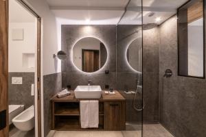 a bathroom with a sink and a shower at Hotel Villa Monica in Dobbiaco +29 photos