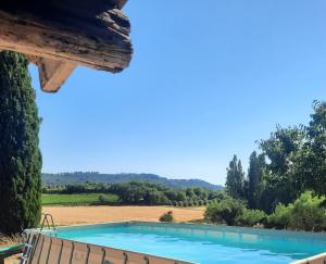 a pool with a view of a field and trees at l'Estagnol in Ansouis