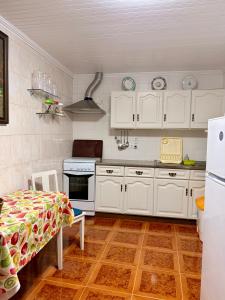 a kitchen with white cabinets and a stove top oven at Vista do Pilar in Conceição