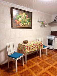 a kitchen with a table and two chairs and a painting on the wall at Vista do Pilar in Conceição +20 photos