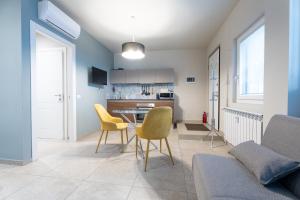 a kitchen and living room with yellow chairs and a table at La casa di Aurora in Pavia +3 photos