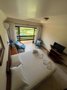 a bedroom with a large white bed and a living room at Tureck Garten Hotel in Corupá +136 photos