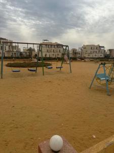 an empty playground with swings and a volley ball at ريفيرا 1 in Ras Sedr