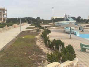 a garden with a pool and a boat in a park at ريفيرا 1 in Ras Sedr