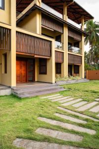 a building with a grass yard in front of it at illa - By the sea in Udupi