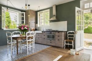 a kitchen with green walls and a table and chairs at La Petite Affolante in Samois-sur-Seine