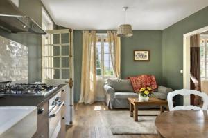 a kitchen and living room with a couch and a table at La Petite Affolante in Samois-sur-Seine +11 photos