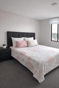 a bedroom with a large bed with pink pillows at Jacinta in Puerto Montt
