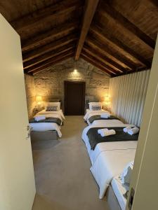 a row of beds in a room with wooden ceilings at Casa da eira in Santo Emilião
