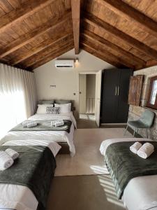 a bedroom with three beds and a chair at Casa da eira in Santo Emilião