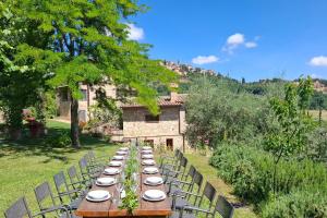 a long table with plates and chairs in front of a building at Villa Montepulciano by Mmega in Montepulciano +37 photos