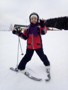 a young child standing on skis in the snow at Біля лісу Шале з двома спальнями in Slavske