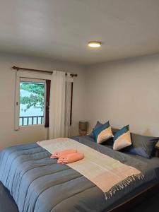 a bedroom with two beds with blue pillows and a window at Libong haven in Ko Kwang +19 photos