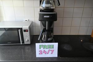 a coffee maker on a counter with a free sign at Dutchies Hostel in Amsterdam