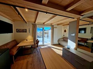 a living room with a desk and a table and a couch at Praterhof Chalet in Südtirol - Natur, Ruhe & Bergblick in Bressanone