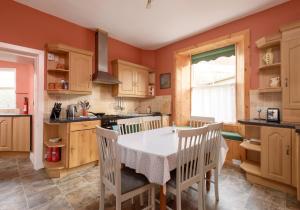 a kitchen with a table and chairs in a room at Sandy Neuk in North Berwick