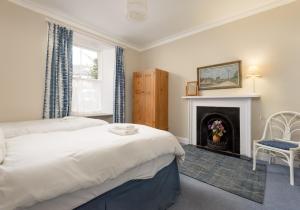 a bedroom with a bed and a fireplace at Sandy Neuk in North Berwick