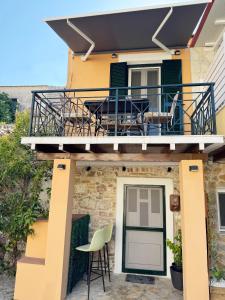 a house with a balcony with a table and chairs at Burnelia Vacation Maisonette in Lefkimmi