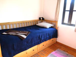 a bedroom with a bed with blue sheets and a window at The Red Konak in Veliko Tŭrnovo