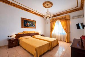 a bedroom with two beds and a chandelier at Euro Hotel Iglesias in Iglesias +75 photos