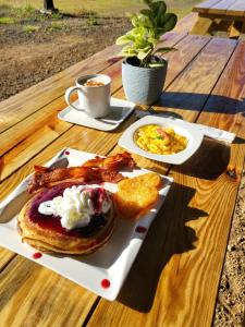 a plate of breakfast food on a wooden table at Santa Catalina Surf Studios- Ocean Adventures in Santa Catalina