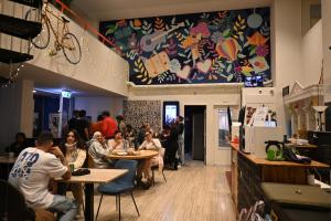 a group of people sitting at tables in a restaurant at Dutchies Hostel in Amsterdam