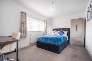 a bedroom with a bed and a desk in it at 3 Bedroom Spacious Bella Range Homes in Hornchurch