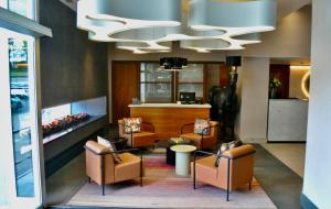 a lobby with chairs and a chandelier at Sandman Signature Newcastle Hotel in Newcastle upon Tyne