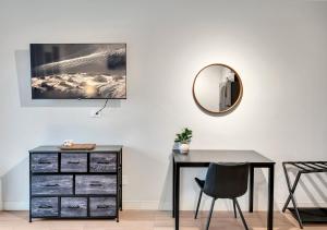 a desk with a mirror and a dresser at Modern Midtown Studio and Private Balcony in Raleigh