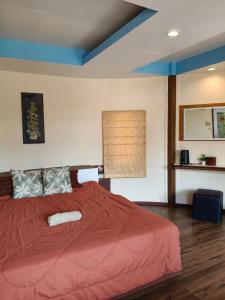 a bedroom with a large bed with a red comforter at Libong haven in Ko Kwang