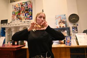 a woman eating a piece of food in a store at Dutchies Hostel in Amsterdam +39 photos