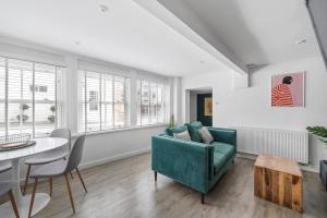 a living room with a green couch and a table at Modern Cottage in Central Exeter in Dean