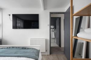a bedroom with a bed and a mirror at Modern Cottage in Central Exeter in Dean +12 photos