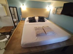 a large white bed with two pillows on it at Lagoon Studio Appartement in Fort-de-France