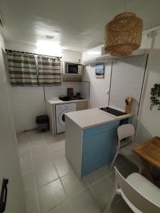 a small kitchen with a counter and a table at Lagoon Studio Appartement in Fort-de-France +3 photos
