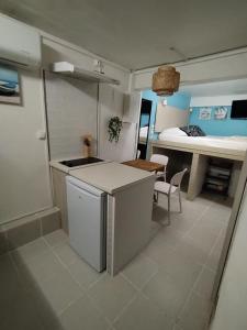 a kitchen with a table and a room with a bed at Lagoon Studio Appartement in Fort-de-France